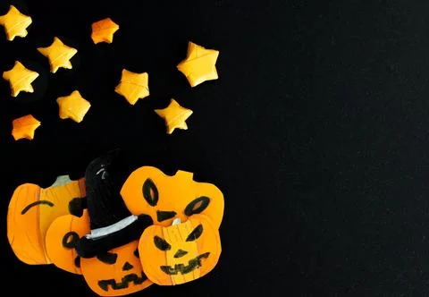 Set of funny pumpkins in starry night. Paper art. Black background. Stock Photos