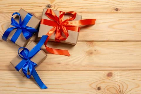 Set of gift boxes wrapped in craft paper and tie red satin and blue ribbon. C Stock-Fotos