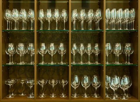 Set of glasses for different alcoholic drinks and cocktails on wood shelf bac Stock Photos