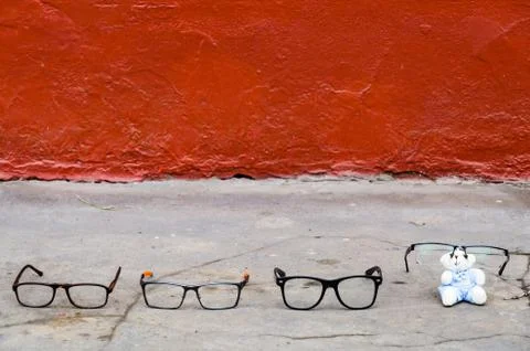 Set of glasses on the pavement that refers to a complete family that wears Stock Photos