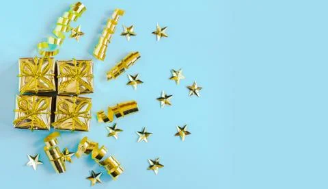Set of gold gift boxes, streamers and stars on a blue background. Holiday Stock Photos