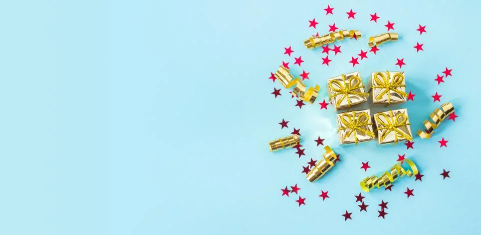 Set of gold gift boxes, streamers and red stars on a blue background. Holiday Stock Photos