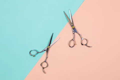 A set of hairdressing tools from two scissors on a colored background. Stock Photos