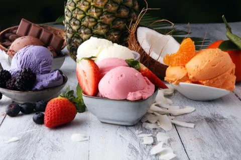 Set of ice cream scoops of different colors and flavours with berries, nuts a Stock Photos