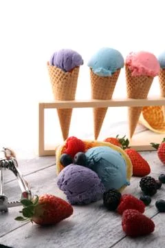 Set of ice cream scoops of different colors and flavours with blueberries, ra Stock Photos