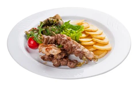 Set of kebabs with vegetable garnish on a white plate Stock Photos
