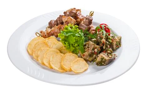 Set of kebabs with vegetable garnish on a white plate Stock Photos
