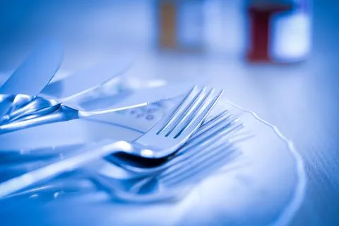 Set of kitchen cutlery arranged on empty plate Stock Photos