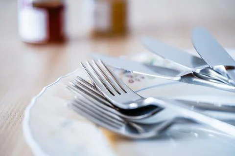 Set of kitchen cutlery arranged on empty plate Stock Photos