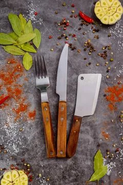 Set of kitchenware and spices on dark background. Stock Photos