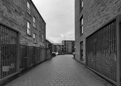 A set of large open gates leading to a private parking area for residents. Stock Photos