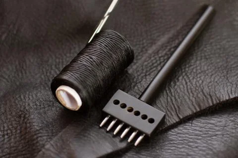 Set of leather work tools on black leather. Workplace for shoemaker. Stock-Fotos