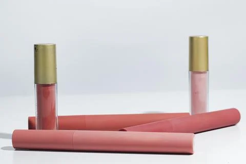 Set of lip products featuring liquid lipsticks in soft hues and sleek packa.. Stock Photos