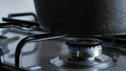Set lower flame of kitchen stove. To use less gas to cook, cook on low heat.  Stock Footage 212047662