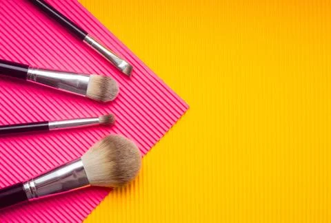 Set of makeup brushes against multicolor background. Top view point, flat lay Stock Photos