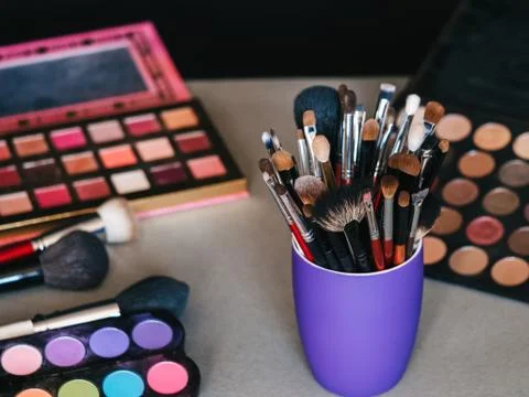 Set of makeup brushes on background of professional eye shadow pallets Stock Photos