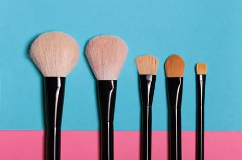 Set of makeup brushes on blue background. Stock Photos