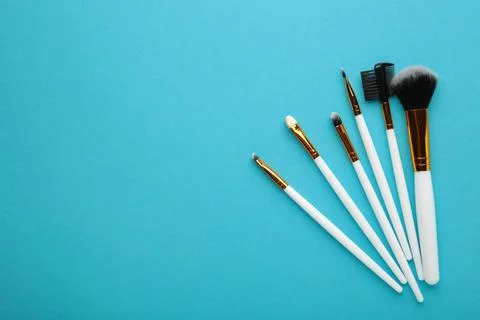 Set of makeup brushes on blue background. Stock Photos