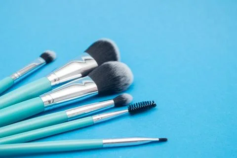Set of makeup brushes on blue background. Stock Photos
