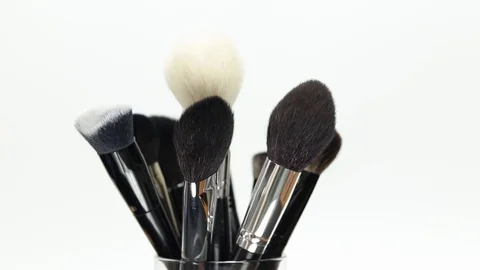 A set of makeup brushes rotates on a white background. Stock Footage 128191114