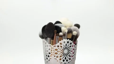 A set of makeup brushes rotates on a white background. Stock Footage 128191260