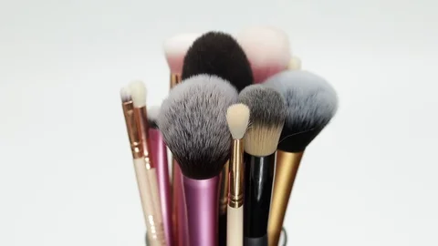 A set of makeup brushes rotates on a white background. Stock Footage 128191373