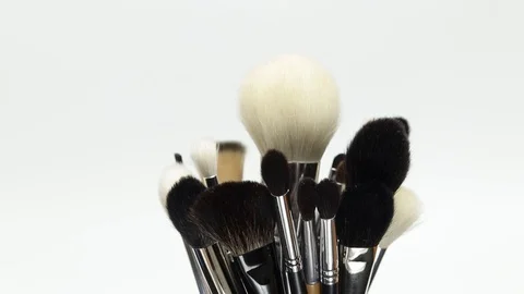 A set of makeup brushes rotates on a white background. Stock Footage 128191402