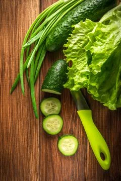 Set for making a salad of fresh herbs cucumbers and onions on vintage table. Stock Photos