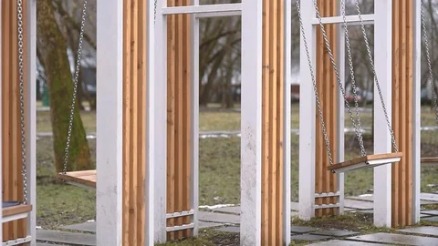 A set of many empty swings swinging in slow motion Stock Footage 125856907