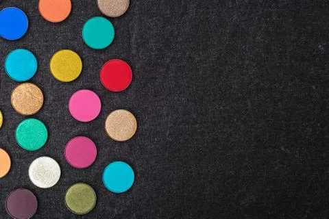 Set of many eyeshadows on a black textile Stock Photos