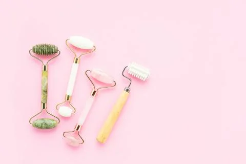 Set of massage rollers for face on pink background. Selfcare, skincare concept Stock Photos