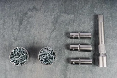 Set of metal drill bits and screws on gray surface Stock Photos