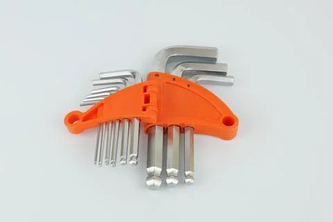 Set of metal hex keys in different sizes arranged in a bright orange plasti.. Foto stock