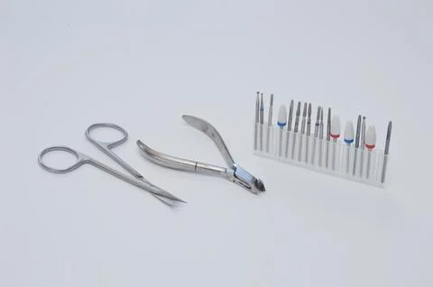 A set of metal tools for hardware manicure on a neutral white background. Stock Photos