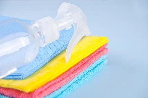 Set of Microfiber cleaning towels and sprayer over blue background 库存照片