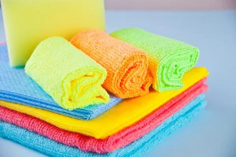 Set of Microfiber cleaning towels and sprayer over blue background Stock Photos