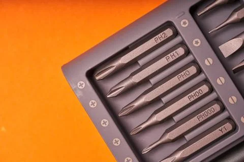 A set of miniature bits for the screw driver on orange background Stock Photos