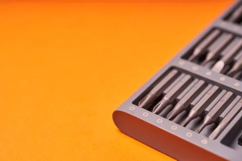 A set of miniature bits for the screw driver on orange background Stock Photos