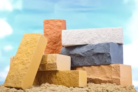 Set of multi-colored ceramic bricks on the sand at the blue sky background Stock Photos