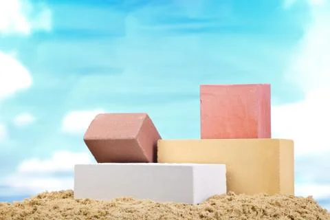 Set of multi-colored ceramic bricks on the sand at the blue sky background Stock Photos