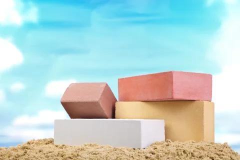 Set of multi-colored ceramic bricks on the sand at the blue sky background Stock Photos