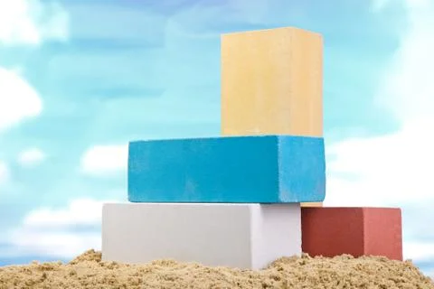 Set of multi-colored ceramic bricks on the sand at the blue sky background Stock Photos