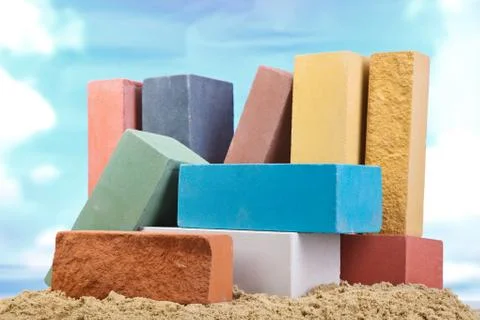 Set of multi-colored ceramic bricks on the sand at the blue sky background Stock Photos