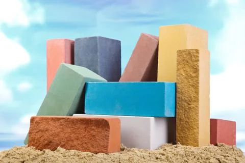 Set of multi-colored ceramic bricks on the sand at the blue sky background Stock Photos