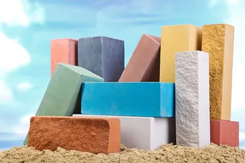 Set of multi-colored ceramic bricks on the sand at the blue sky background Stock Photos