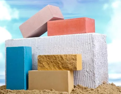 Set of multi-colored ceramic bricks on the sand at the blue sky background Stock Photos