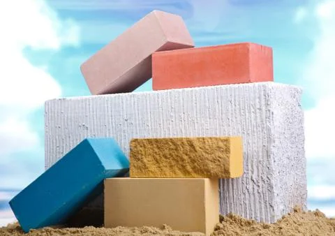 Set of multi-colored ceramic bricks on the sand at the blue sky background Stock Photos