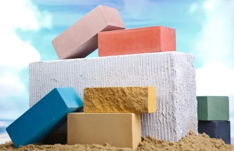 Set of multi-colored ceramic bricks on the sand at the blue sky background Stock Photos