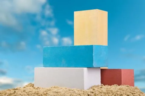 Set of multi-colored ceramic bricks on the sand at the blue sky background Stock Photos