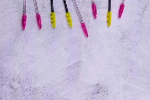 Set of multi-colored eyebrow brushes on a concrete background. Stock Photos